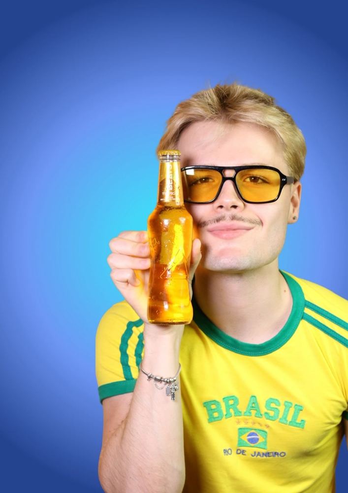 Modelo con una botella de Beats Tropical sobre fondo azul